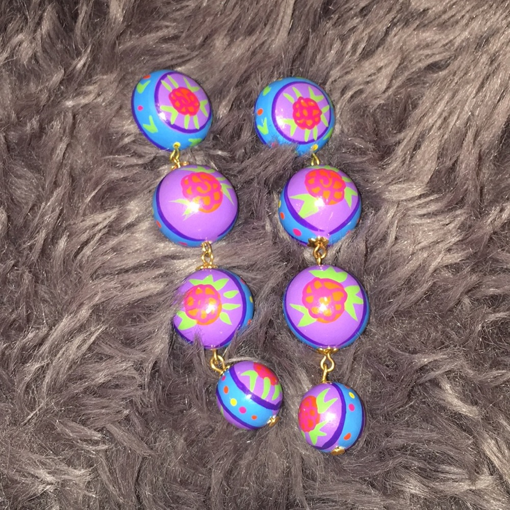 Long colorful earrings with flower details.